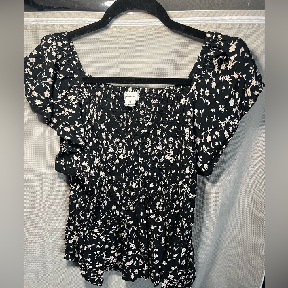 Black blouse with white floral design size xl looks more like a medium.